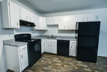 A kitchen with black and white appliances and cabinets.